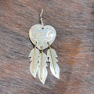 Heart pendant with feathers.